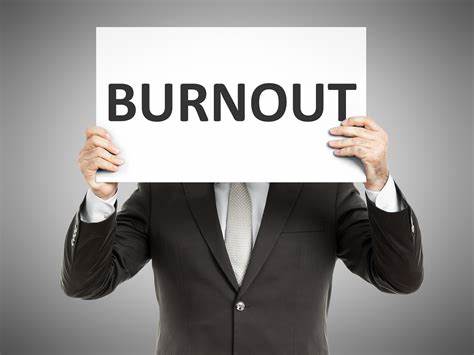A man holding a sign that reads “Burnout”